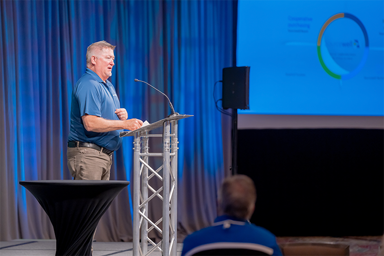 Robb Reid, presenting on stage to group